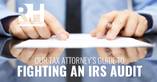 A man looks over a contract to hire a tax attorney to fight his IRS audit