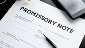white paper with PROMISSORY NOTE written at the top in bold black letters